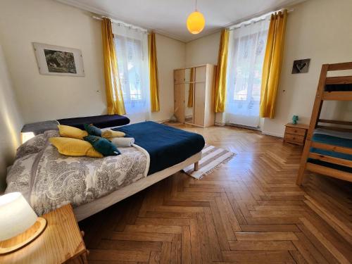 um quarto com uma cama e piso em madeira em Gite Jonquille 2 à 8 personnes avec SPA em Ventron