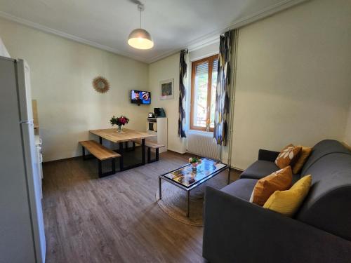 a living room with a couch and a table at Gîte Jonquille, 2 à 8 personnes avec salle de jeux et SPA dans la résidence in Ventron