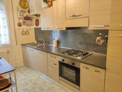 cocina con armarios de madera y horno con fogones en Casa Daria, en Rapallo
