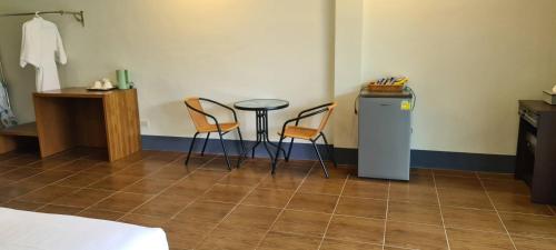 a room with two chairs and a table and a refrigerator at Phu Siab Mhok@KhaoSok in Khao Sok