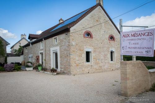 a brick building with a sign in front of it at Aux Mésanges in Labergement-Foigney