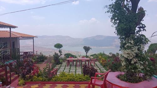 een tuin met een tafel en stoelen en uitzicht bij KAASH PATHAR DREAM HOUSE in Satara