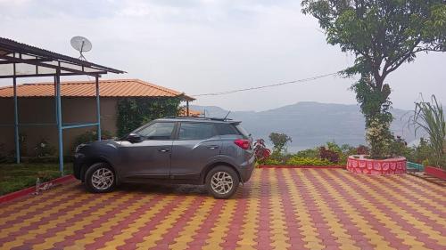 a gray suv parked on a checkered parking lot at KAASH PATHAR DREAM HOUSE in Satara