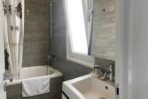 baño con lavabo, bañera y ventana en Boutique Mobile Homes UlikaRovinj en Rovinj