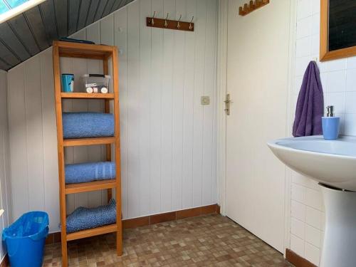 a bathroom with a sink and a shelf with towels at Chez Milo, rural cottage in Roches