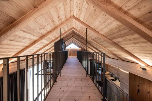 a wooden corridor in a building with a wooden ceiling at Spornberg Mountain Living Nordberg in Soprabolzano