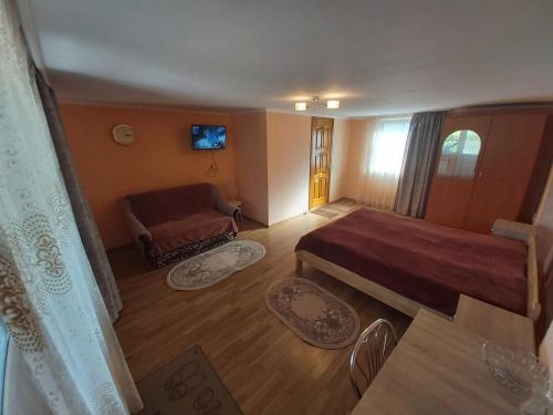 ein kleines Zimmer mit einem Bett und einem Sofa in der Unterkunft Садиба на Хуторі in Solotschyn