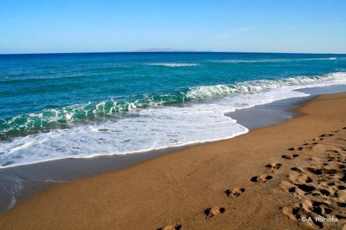 a beach with footprints in the sand and the ocean at Studio Marina in Sivas beautiful Village in Sívas