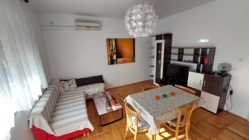 ein Wohnzimmer mit einem Sofa und einem Tisch in der Unterkunft Apartman SABADIN in Njivice