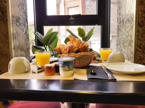 - une table avec un panier de pain et des verres de jus d'orange dans l'établissement Chambres d'Hôtes La petite Salamandre, à Étretat
