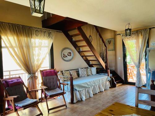 a bedroom with a bed and a staircase and two chairs at Villa La dame blanche in Skala Potamias