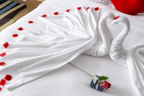 two white towels on a bed with red hearts at Guangzhou Baiyun Airport Rejoice by Argyle Hotel Rehe Metro Exit B --Free shuttle bus is provided during the 138th Canton Fair in Guangzhou