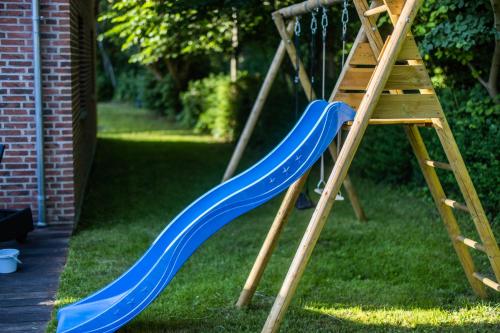 a blue slide next to a wooden ladder at Lake House Central Lyngby in Kongens Lyngby