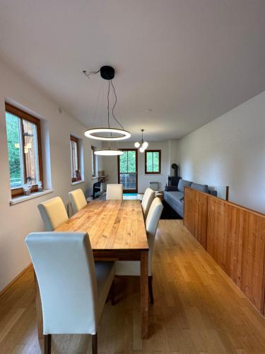 uma sala de jantar e sala de estar com uma mesa de madeira e cadeiras em Appartment Rosennock em Sankt Oswald