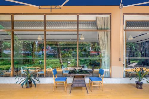 a dining room with a table and chairs and windows at Guangzhou Baiyun Airport Rejoice by Argyle Hotel Rehe Metro Exit B --Free shuttle bus is provided during the 138th Canton Fair in Guangzhou