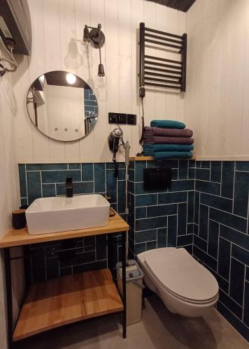 a bathroom with a sink and a toilet and a mirror at Apartamenty być morze in Krynica Morska
