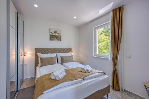 a bedroom with a large bed with towels on it at Villa IN in Nova Vas