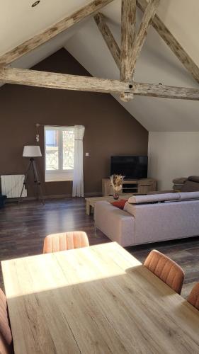 un salon avec une table et un canapé dans l'établissement Charmante maison à Haybes, à Haybes