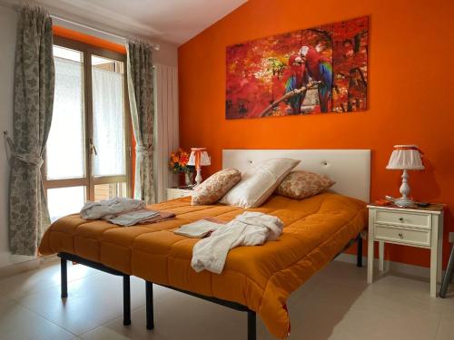 un letto in una camera con parete arancione di Pousada Copacabana Praia - AFFITTACAMERE - Casa Vacanza a Porto Sant'Elpidio a Porto SantʼElpidio