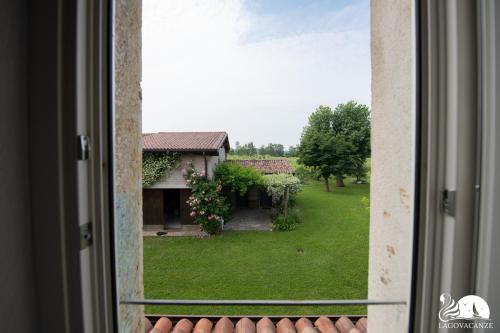 een raam met uitzicht op een huis bij Cascina Polone in Sirmione