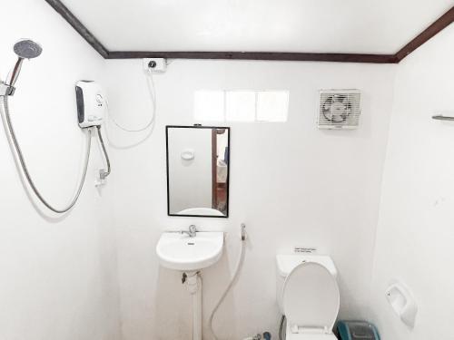 a bathroom with a toilet and a sink at Siargao Tropic Hostel in General Luna