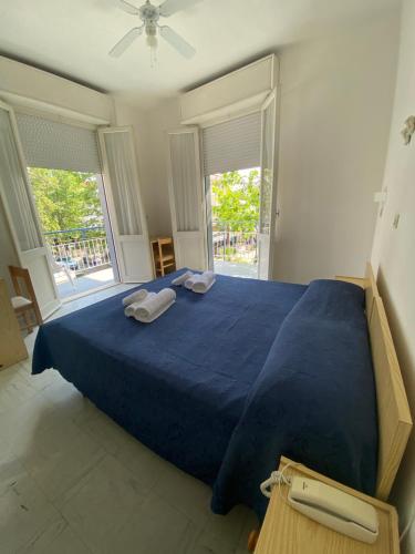 ein Schlafzimmer mit einem blauen Bett mit zwei Handtüchern darauf in der Unterkunft B&B Hotel Lucciola in Cattolica