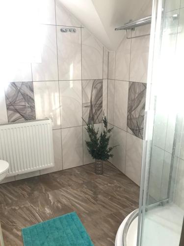 a bathroom with a shower and a potted plant at Viimsis eraldi 36m2-suurune tuba eramajas in Lubja