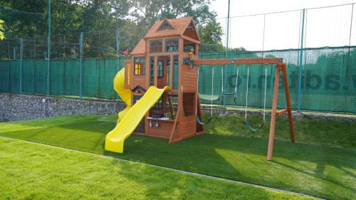 a small playground with a slide in a yard at Pensiunea Magic in Băile Govora