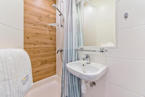 a bathroom with a sink and a shower at Piramida Medical SPA in Mrzeżyno