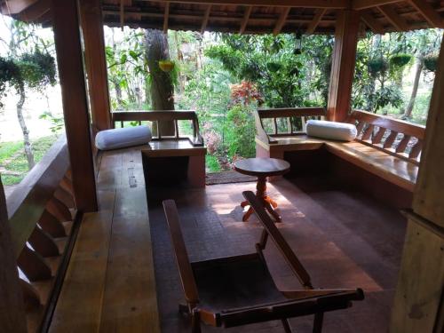 a porch of a house with chairs and a table at Zyamadhari in Mananthavady