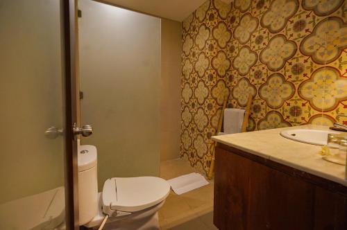 a bathroom with a toilet and a sink at Pertiwi Resort & Spa in Ubud