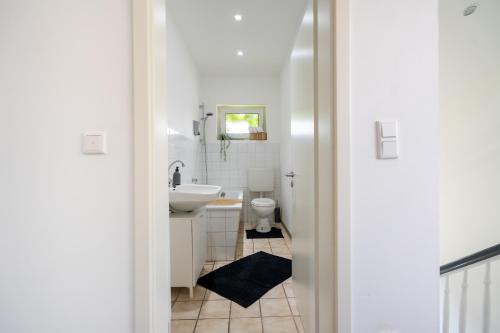 La salle de bains blanche est pourvue d'un lavabo et de toilettes. dans l'établissement XXL Superior Apartment 2 - 9 Personen, à Castrop-Rauxel