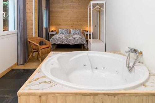 bañera grande en una habitación con cama en Apartamentos El Bosque De Cubas en Cubas