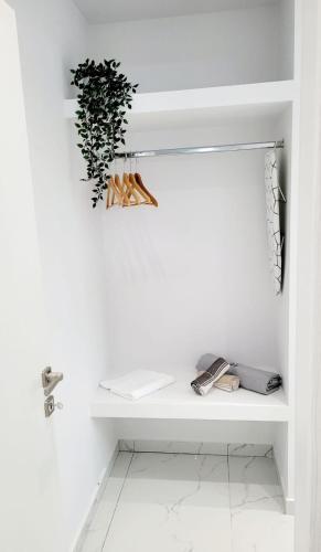 a white room with a shelf with a plant on it at Astre&Jeanne suites in Sozopoli