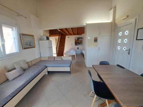Habitación con 2 camas, mesa y cocina. en Oceanides Apartments, en Kourouta
