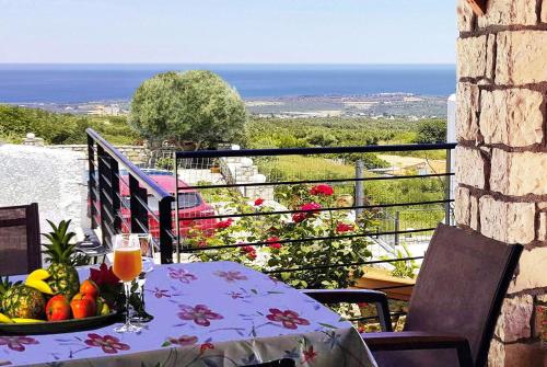 einen Tisch mit einer Obstschale auf dem Balkon in der Unterkunft Villa Sunset with stunning sea view, kids area and hammocks on roof terrace in Agia Triada