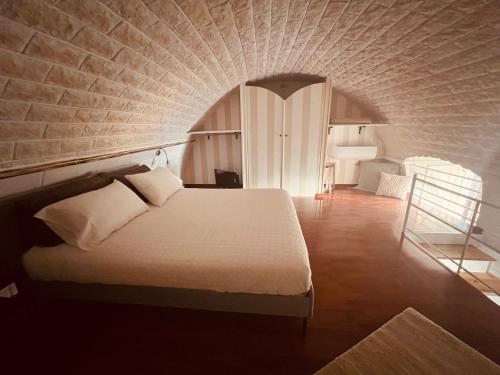 a bedroom with a bed and a brick wall at GILU' in Adelfia
