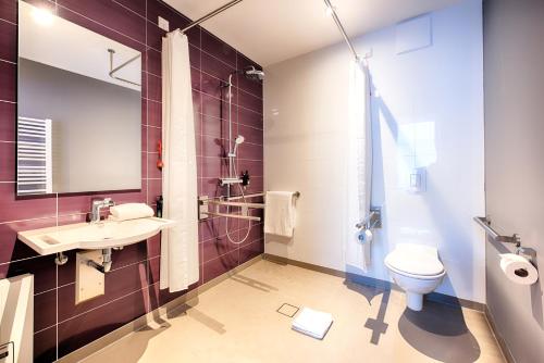 Premier Inn Lübeck City Stadtgraben في لوبيك: حمام مع مرحاض ومغسلة ودش