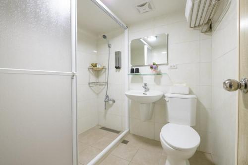 a white bathroom with a toilet and a shower at 乘風之旅溫馨包層華廈每日只接待一組客人最多6人 in Yilan City