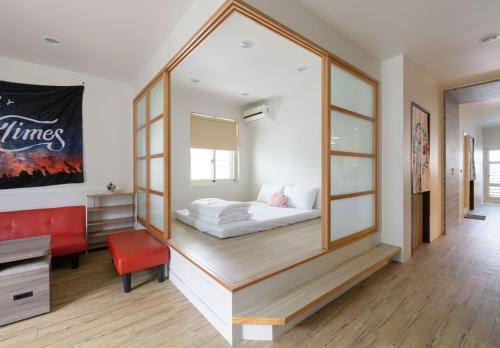 1 dormitorio con 1 cama y 1 silla roja en 乘風之旅溫馨包層華廈每日只接待一組客人最多6人, en Yilan City