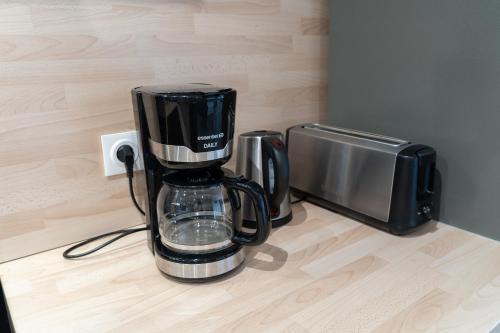 - une cafetière assise sur un comptoir à côté d'un four micro-ondes dans l'établissement Le Moulin Rouge de CLAIRMARAIS 