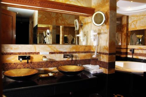 a bathroom with two wooden sinks and a mirror at Holiday Inn Kuwait by IHG in Kuwait