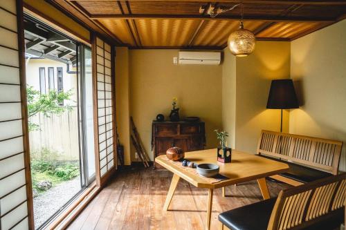 una sala da pranzo con tavolo e finestra di Kyo no Yado Sangen Ninenzaka a Kyoto
