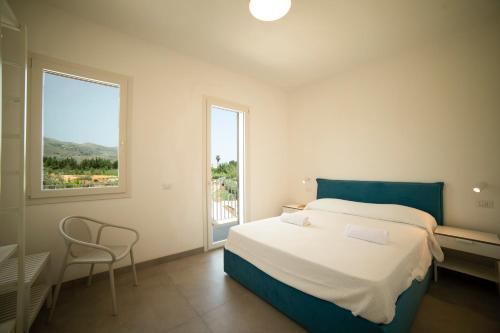 ein Schlafzimmer mit einem Bett und einem großen Fenster in der Unterkunft Blu Home Scopello in Castellammare del Golfo