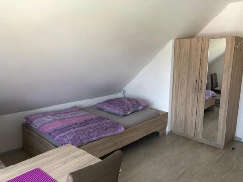 a small bedroom with a bed and a mirror at WeinMotel Simon 1 a in Alzenau in Unterfranken