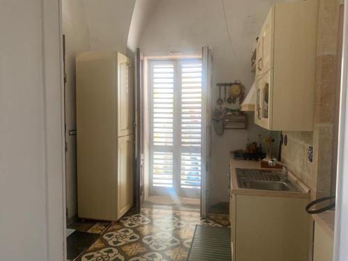 uma cozinha com um frigorífico branco e um lavatório em Casa Contadina em Giuliano