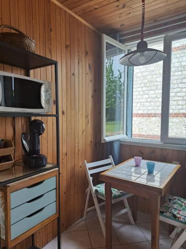 une salle à manger avec une table et un four micro-ondes dans l'établissement Maisonnette Pont de l’Arche, à Pont-de-lʼArche