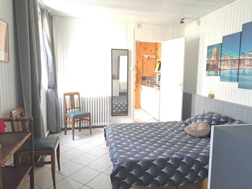 une chambre avec un lit, une table et des chaises dans l'établissement Maisonnette Pont de l’Arche, à Pont-de-lʼArche