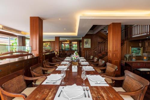 a dining room with a long table and chairs at Gala Beachfront Villa in Pattaya South