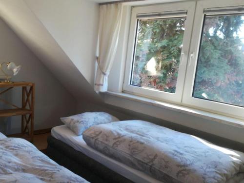 1 dormitorio con 2 camas y ventana en Ferienwohnung S. Viering en Bernau bei Berlin